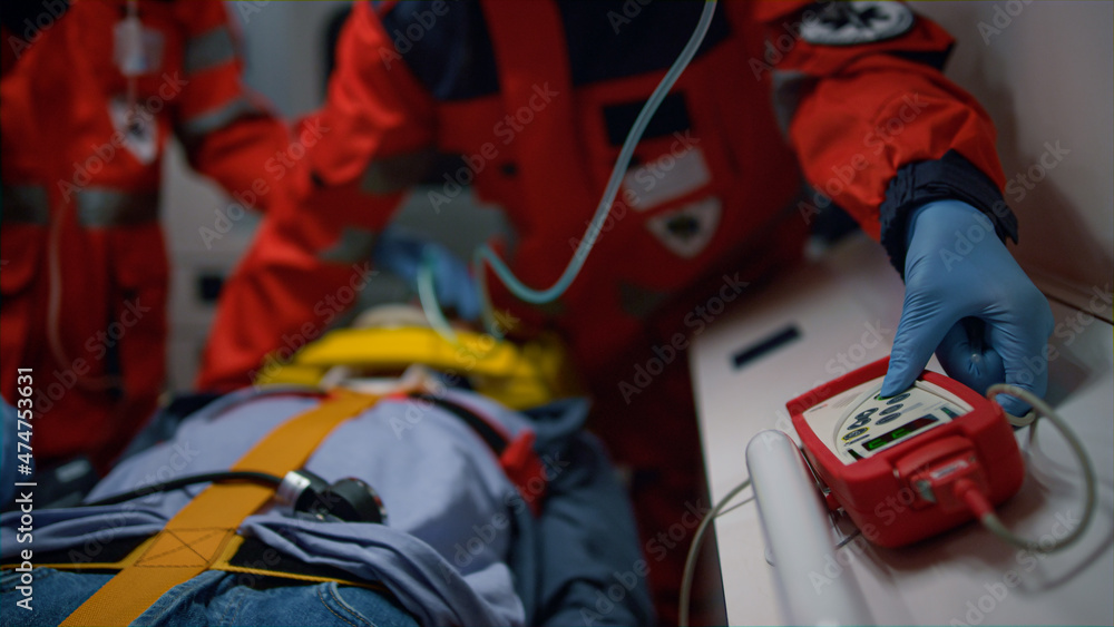 Paramedics hands in gloves providing emergency care of patient in ambulance car Paramedics hands in gloves providing emergency care of patient in ambulance car