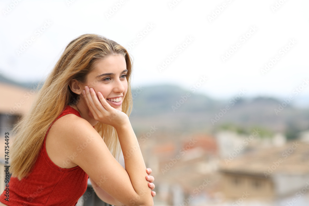 Obraz premium Happy teenage girl contemplating from balcony