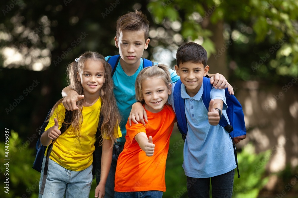 Group of happy school child with schoolbag in outdoor park Group of happy school child with schoolbag in outdoor park