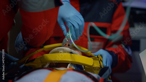 Emergency medical doctors providing medical help for patient in oxygen mask