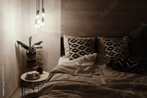 modern bedroom in light tones at night time
