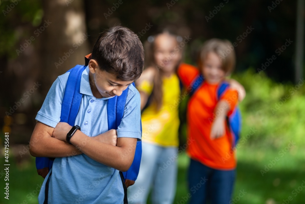 Naklejka premium Upset school girl on classmates background