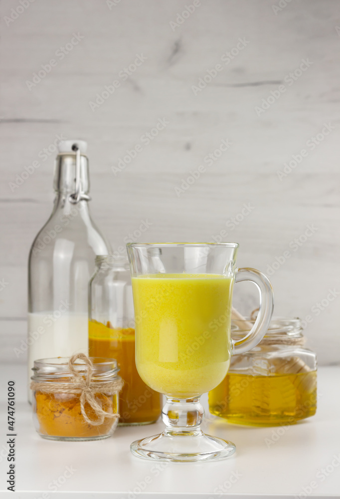 A glass of golden milk, ayurvedic turmeric beverage and ingredients