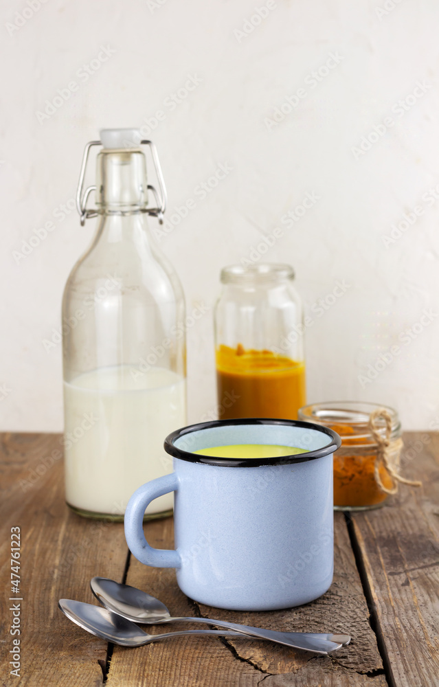 A cup of golden milk, ayurvedic turmeric beverage and ingredients A cup of golden milk, ayurvedic turmeric beverage and ingredients