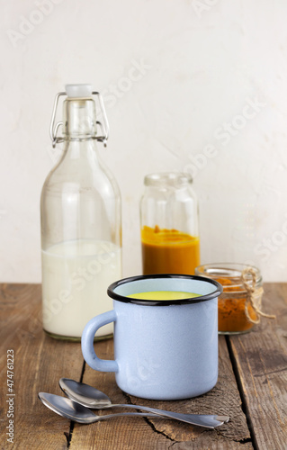 A cup of golden milk, ayurvedic turmeric beverage and ingredients