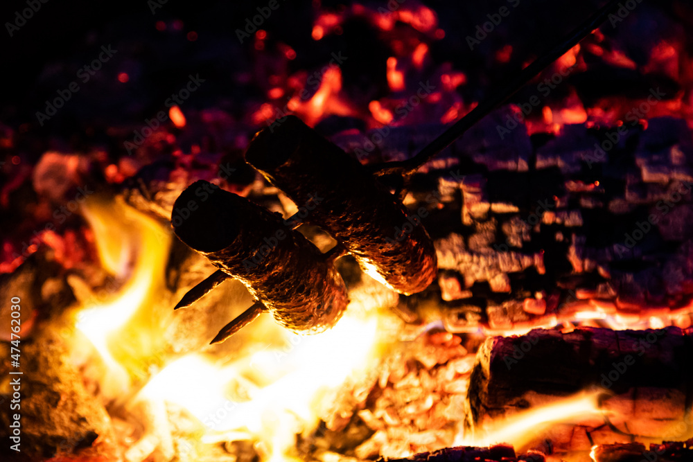 Fototapeta premium Sausage barbecue baking and cooking with fire flames and fat