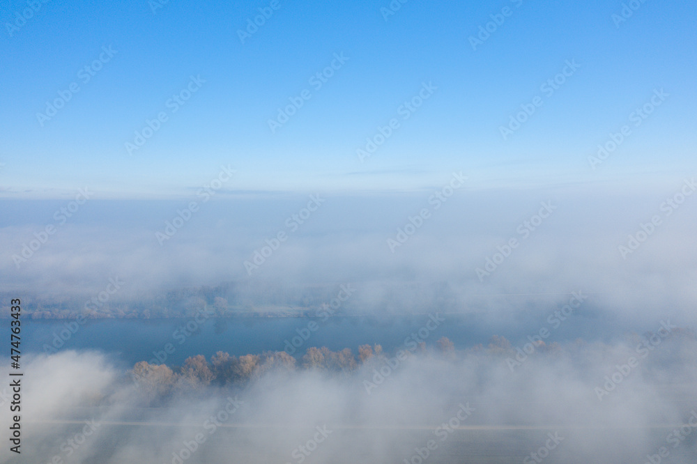 The Loire in the middle of the countryside in the fog in Europe, in France, in the Center region, in the Loiret, towards Orleans, in Winter, on a sunny day.