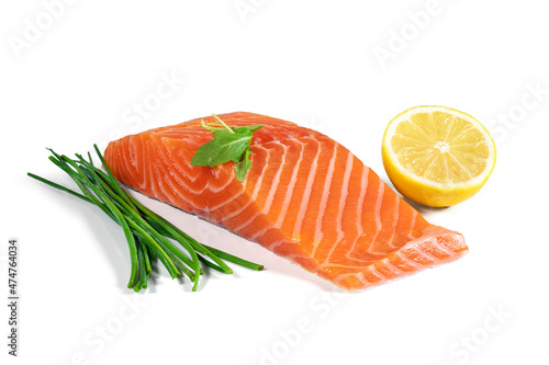 Fresh raw salmon fish fillet with herbs and lemon isolated from the background