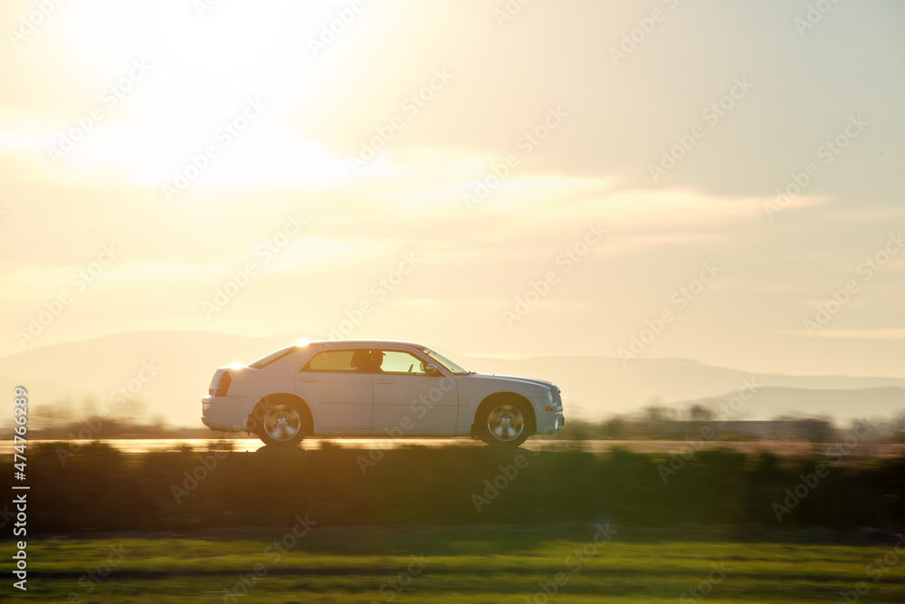 Car driving fast on intercity road at sunset. Highway traffic in evening Car driving fast on intercity road at sunset. Highway traffic in evening