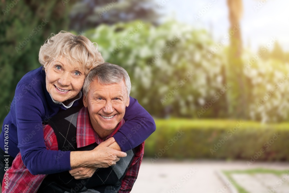 Portrait of lovely happy elderly couple on morning outside in city park,