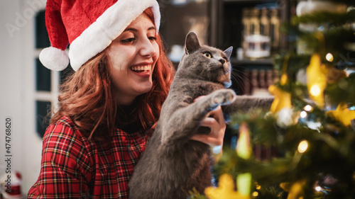 Obraz na plátně Giovane ragazza sistema l'albero di Natale con il suo gatto
