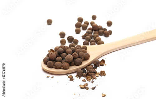 Allspice, pimento spice, Jamaican pepper and shavings in wooden spoon isolated on white 