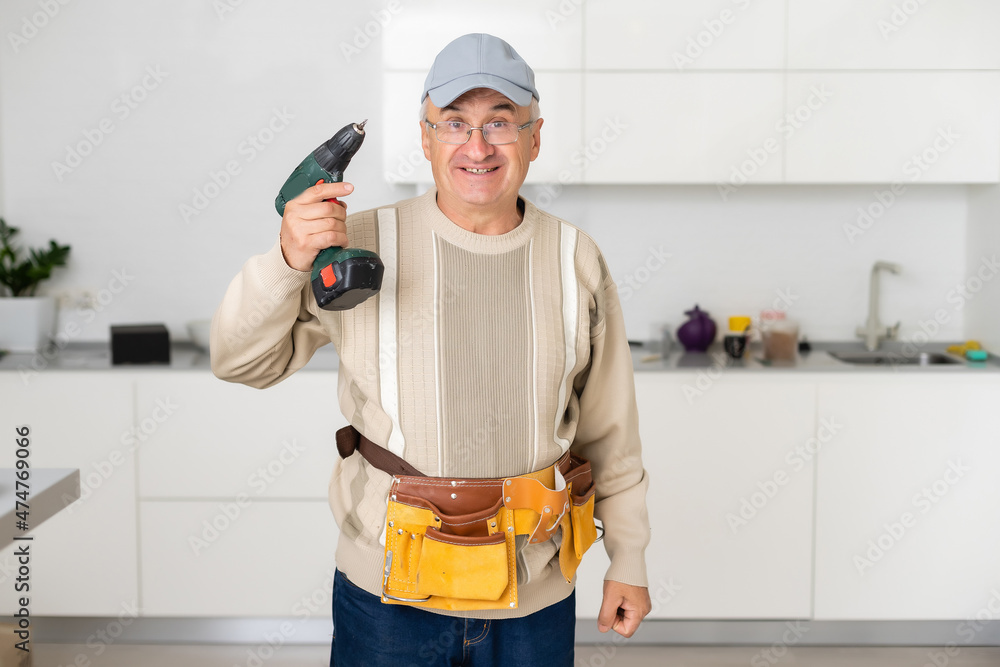 Mature Male Serviceman Repairing With Toolbox In Kitchen Mature Male Serviceman Repairing With Toolbox In Kitchen