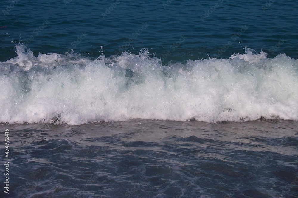 Sea wave with white foam. Blue sea. Sea coast. Russia, Sochi.