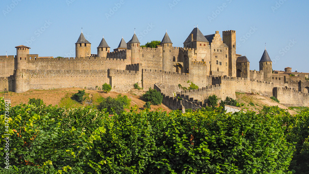 Famous hilltop town or ancient fortress La Cité de Carcassonne with medieval citadel or castle Château Comtal, surrounded by double walls, dotted by 52 towers and turrets, founded in Gallo-Roman times