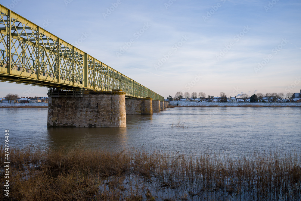 The Loire under the pedestrian bridge of Sully sur Loire under the snow in Europe, in France, in the Center region, in the Loiret, towards Orleans, in Winter, during a sunny day. The Loire under the pedestrian bridge of Sully sur Loire under the snow in Europe, in France, in the Center region, in the Loiret, towards Orleans, in Winter, during a sunny day.