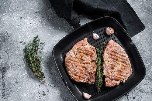 Grilled Pork Tender steaks from fillet meat on grill pan. Gray background. Top view
