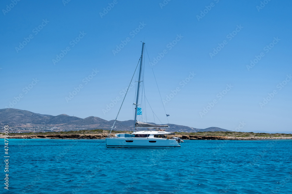 Luxury yacht anchored in emerald water. Panteronisi islet, between Paros Antiparos Cyclades Greece..