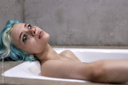 What should I do. Worried female lying on bathtub crying, thinking about something depressing at home. unhappy lady is upset by something, stress and crisis concept, woman in contemplation, take bath