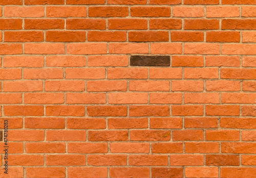 red brick wall with one brown brick highlighted, texture for background