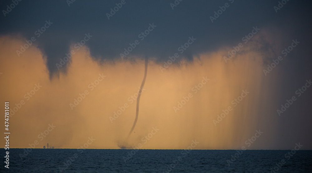 Tornado in the sea during the day against the sky