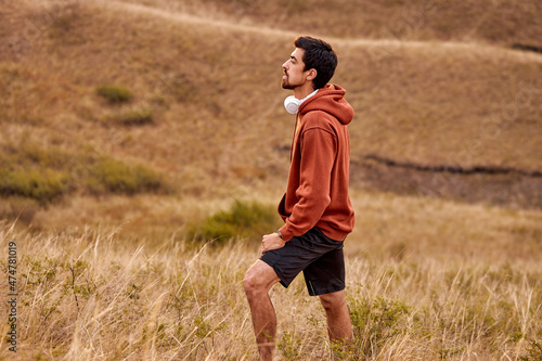 Athlete man running sport. Runner take a break during jogging outdoors with beautiful landscape around. In nature. Male with headphones enjoy the view scene surrounding him, in contemplation
