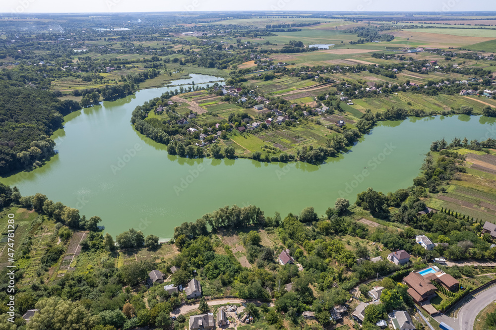 View from drone on village with green nature and river