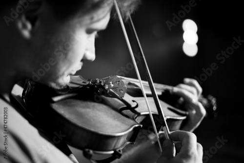 A man plays the violin on the stage of close