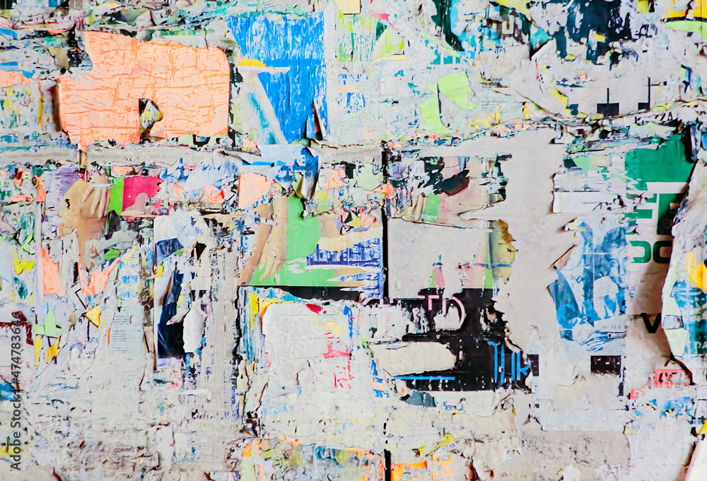 Naklejka premium An unintended collage art poster, made by different layers of worn and torn street ads on a city wall, accumulated over time. 