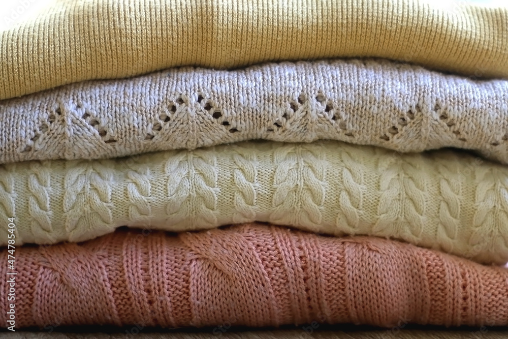 Pile of sweaters in pastel and neutral colors. Selective focus. Pile of sweaters in pastel and neutral colors. Selective focus.