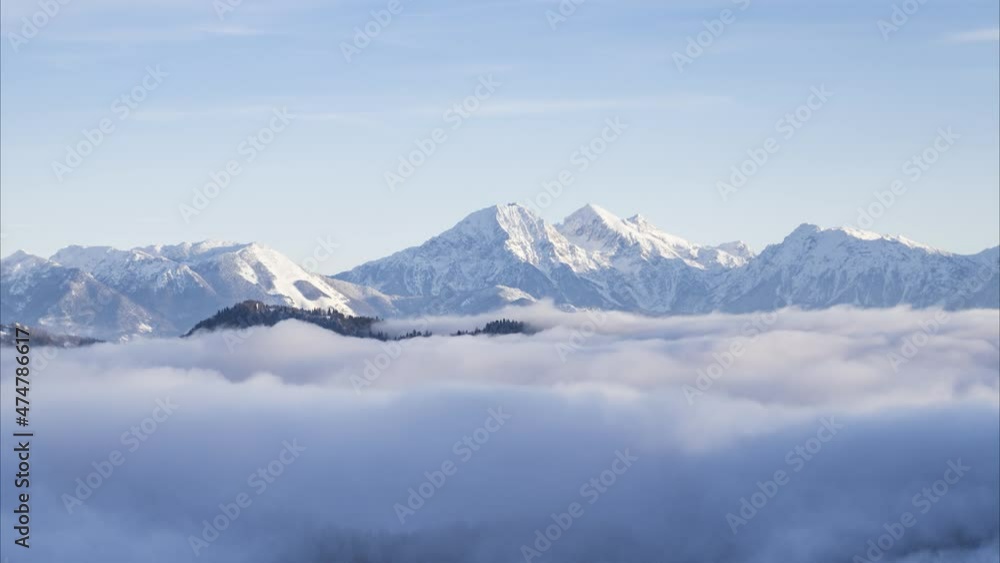 Low inversion clouds moving in alpine valley. Time lapse of fog covering amazing landscape in winter. Snowy mountains in the distance. Pristine nature in Slovenia. Famous Saint Thomas church Low inversion clouds moving in alpine valley. Time lapse of fog covering amazing landscape in winter. Snowy mountains in the distance. Pristine nature in Slovenia. Famous Saint Thomas church