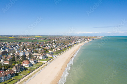 The long sandy beach of Sword beach in Hermanville-sur-Mer in Europe, France, Normandy, towards Ouistreham, in summer, on a sunny day.