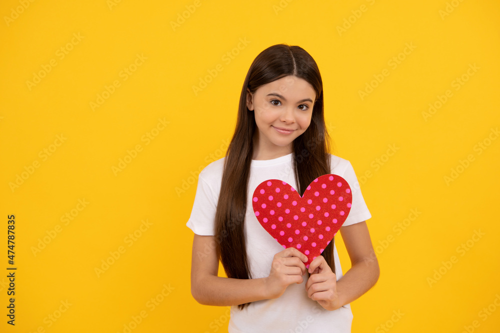 happy child with red heart on yellow background with copy space, charity happy child with red heart on yellow background with copy space, charity