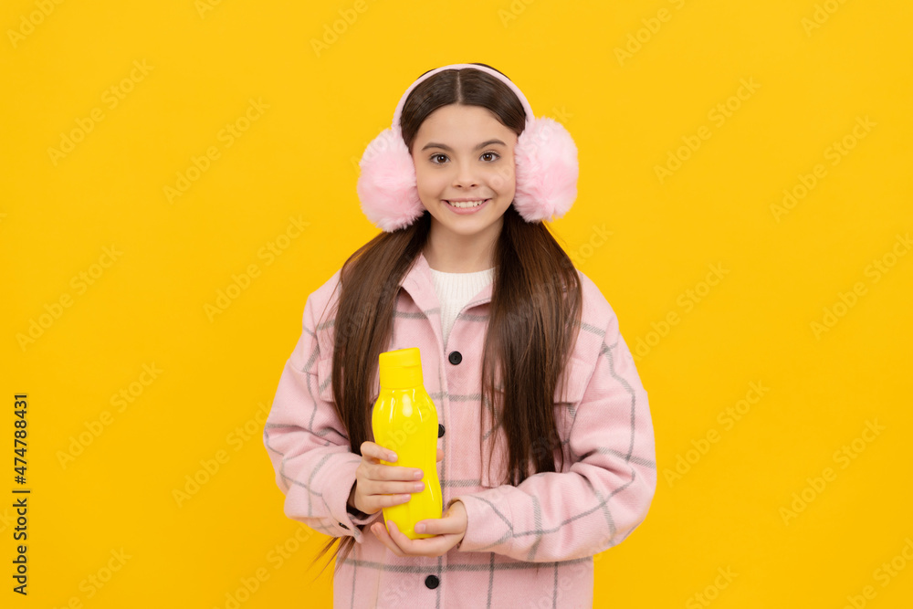 cheerful teen girl in earmuffs with sport water bottle on yellow background, drink cheerful teen girl in earmuffs with sport water bottle on yellow background, drink