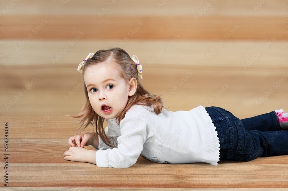 Lying on floor. Little smiling cute child. Concept of emotions, facial expressions. Lying on floor. Little smiling cute child. Concept of emotions, facial expressions.