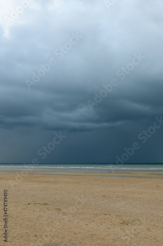 The storm over the beach and the Channel Sea in Europe, France, Normandy, Ouistreham, in summer, on a sunny day.