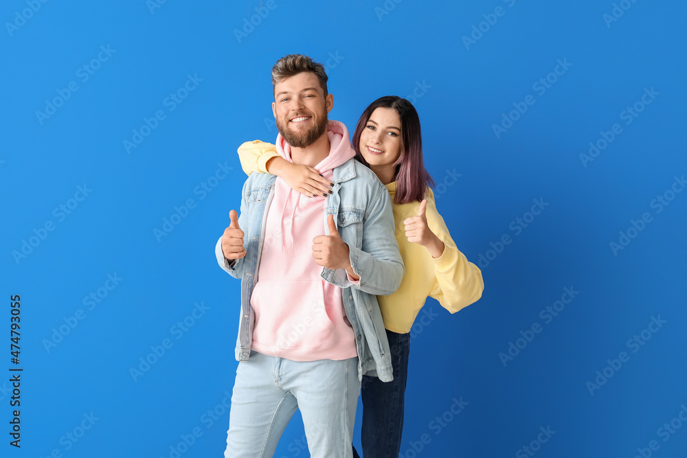 Cool young couple in hoodies on color background Cool young couple in hoodies on color background
