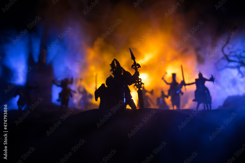 Fototapeta premium Medieval battle scene with cavalry and infantry. Silhouettes of figures as separate objects, fight between warriors on dark toned foggy background with medieval castle.