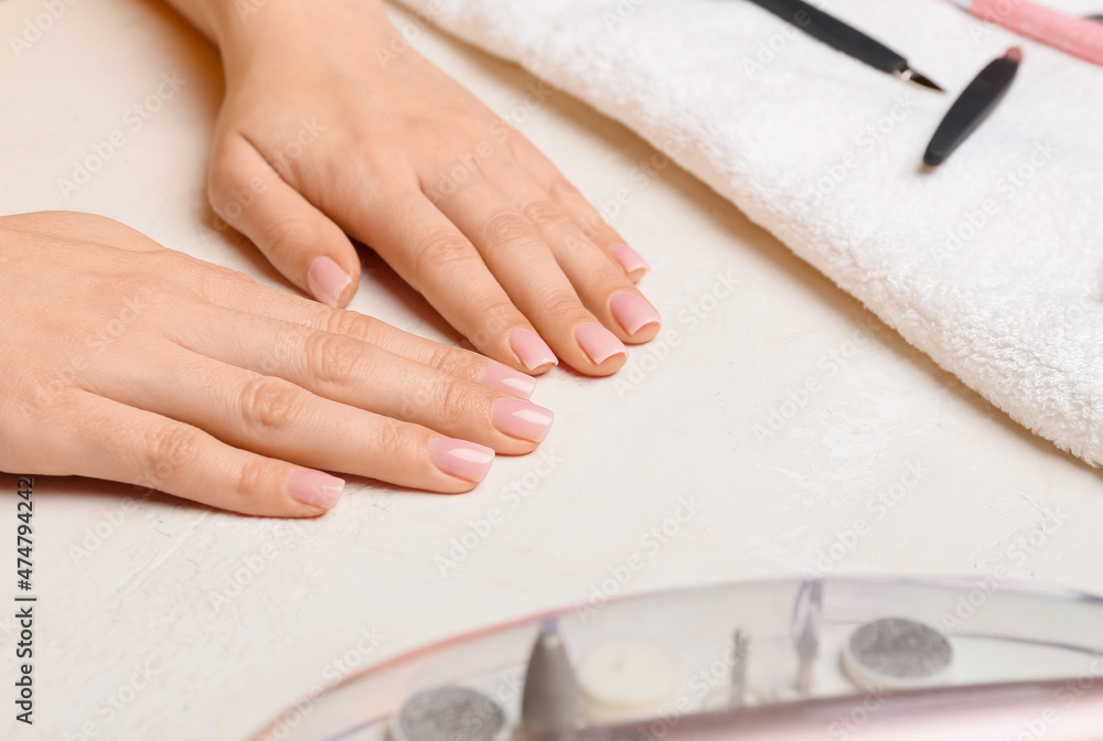 Female hands with gentle manicure on light table, closeup Female hands with gentle manicure on light table, closeup