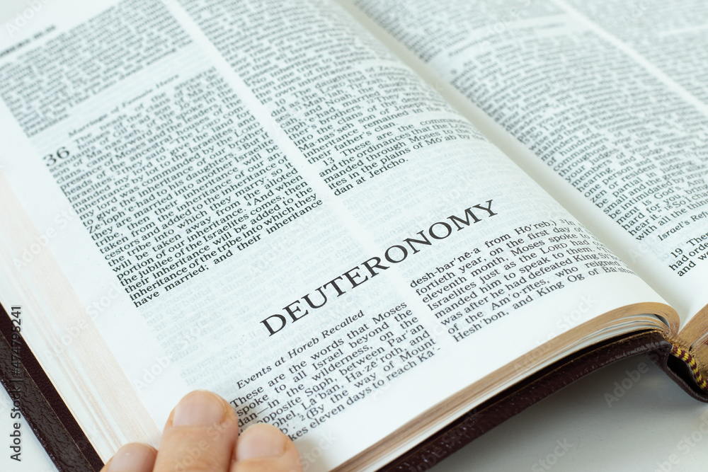 Deuteronomy Holy Bible Book. A close-up of open Old Testament Scripture. Second Law by God Jesus Christ. A Christin biblical concept of hope, faith, trust in the LORD. Studying the Torah. Deuteronomy Holy Bible Book. A close-up of open Old Testament Scripture. Second Law by God Jesus Christ. A Christin biblical concept of hope, faith, trust in the LORD. Studying the Torah.