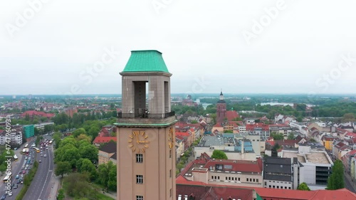 Pull back shot of Rathaus Spandau tower with tower clocks. Aerial view of old town and busy multilane road. Berlin, Germany photo