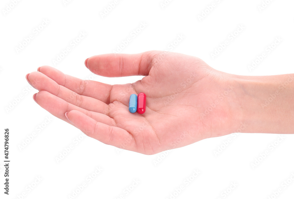 Hand with red and blue pills isolated on white. Concept of choice