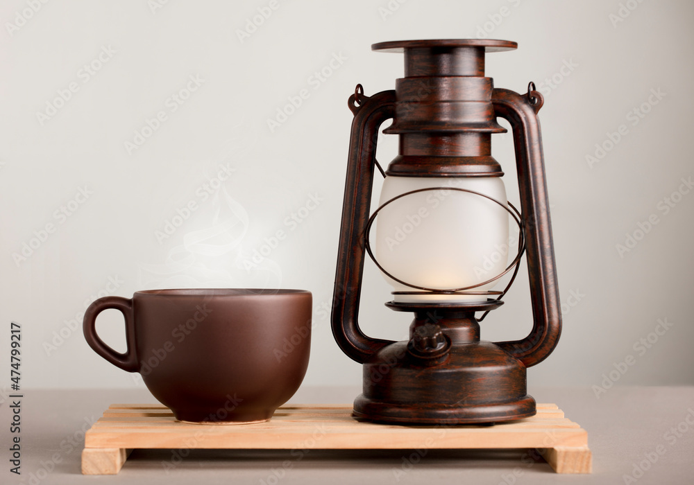 brown cup of coffee with hot steam, on desk with sunlight lamp, yellowish orange background brown cup of coffee with hot steam, on desk with sunlight lamp, yellowish orange background
