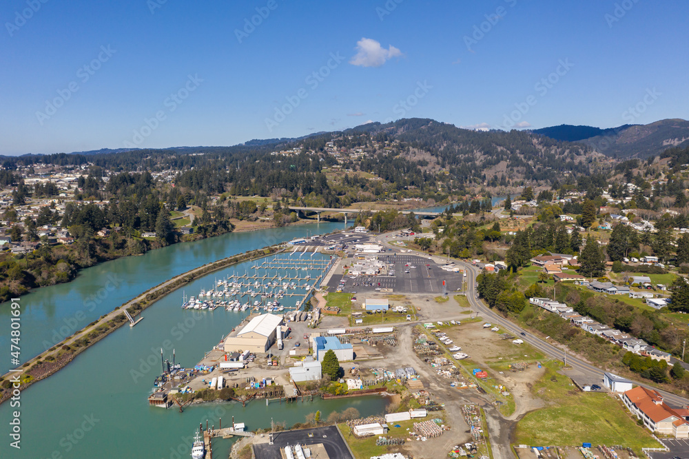 Brookings Oregon marina on sunny day with blue sky, aerial drone shot.