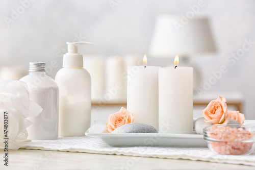 Spa set with burning candles on light background