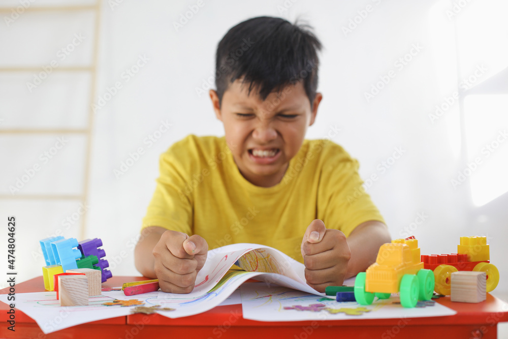 Emotional Tantrum and Angry boy while drawing on paper. Childhood traumatic experience, psychology, psychological, asperger syndrome, asperger's disorder, autistic, autism. Emotional Tantrum and Angry boy while drawing on paper. Childhood traumatic experience, psychology, psychological, asperger syndrome, asperger's disorder, autistic, autism.