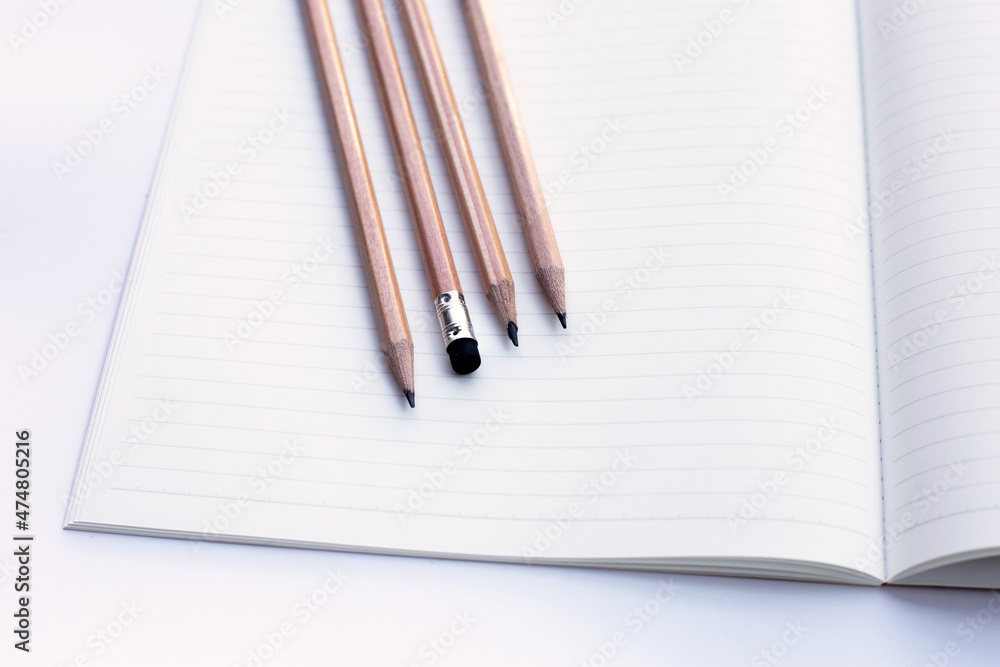 Pencils on notebooks or paper on white background Pencils on notebooks or paper on white background