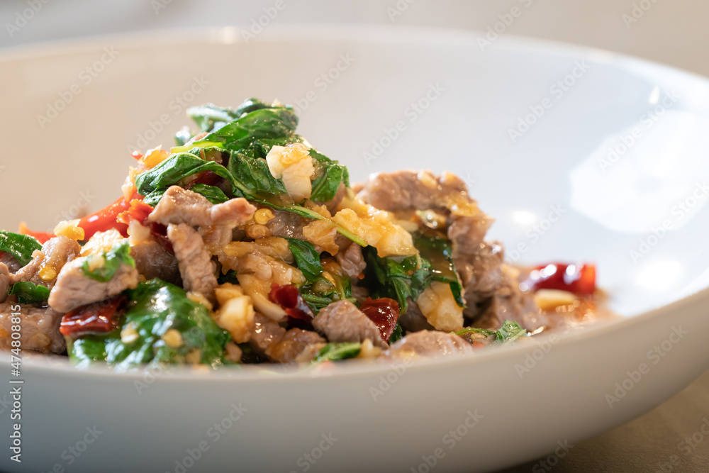 Close up to the warm Stir-Fried Beef Basil, ready to serve and eat. A Famous Thai Food Style in white bowl is set in studio light. Close up to the warm Stir-Fried Beef Basil, ready to serve and eat. A Famous Thai Food Style in white bowl is set in studio light.