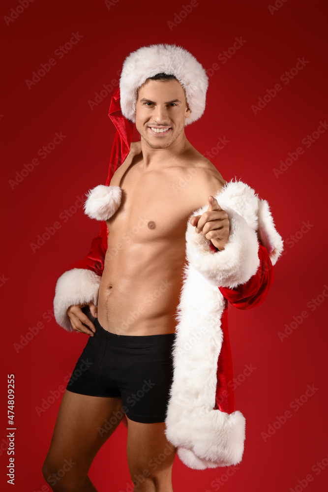 Sexy young man in Santa costume on color background Sexy young man in Santa costume on color background