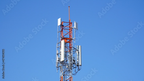 Telecommunication tower of 4G and 5G cellular. Macro Base Station. 5G radio network telecommunication equipment with radio modules and smart antennas mounted on a metal against blue sky background.